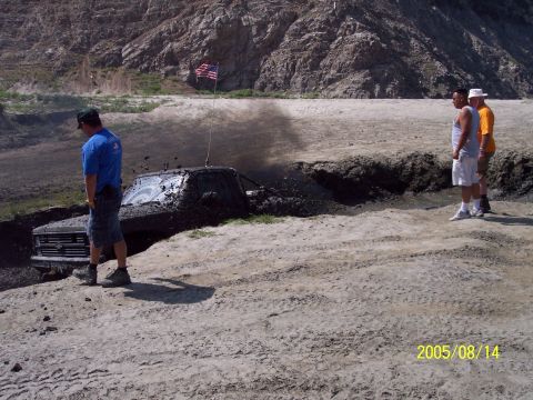 1985 Ford Bronco - Truck stuck in mud with people watching. Date stamp reads 2005/08/14.
