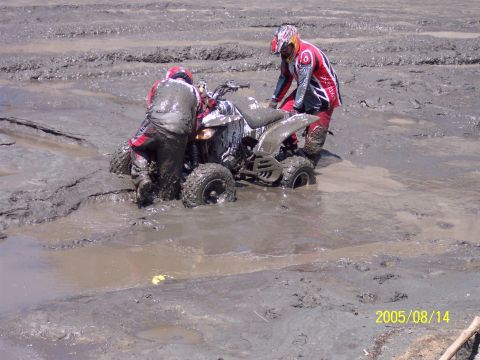 1985 Ford Bronco - Two riders struggle to free a quad bike from deep mud.