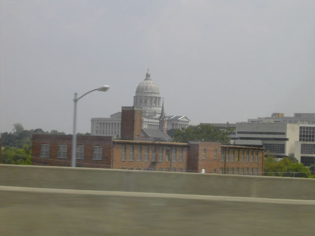 Cityscape with capitol building and brick buildings under a hazy sky