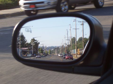 2003 Ford Crown Victoria - Reflection in the side view mirror shows a street with several cars and utility poles. A silver SUV is visible in the upper portion of the…
