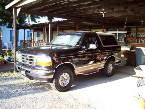 1996 Ford Bronco - This black 1996 Ford Bronco is parked under a carport, showing its 3/4 front view.