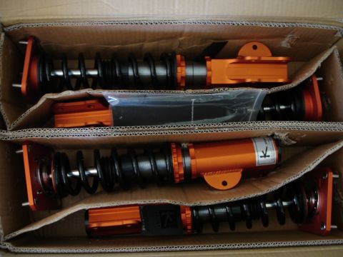 1989 Mazda MX-6 - New suspension coilovers are packaged in a cardboard box, ready for installation.