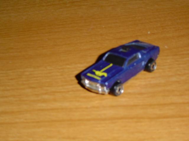 Blue toy car with yellow stripes on a wooden surface
