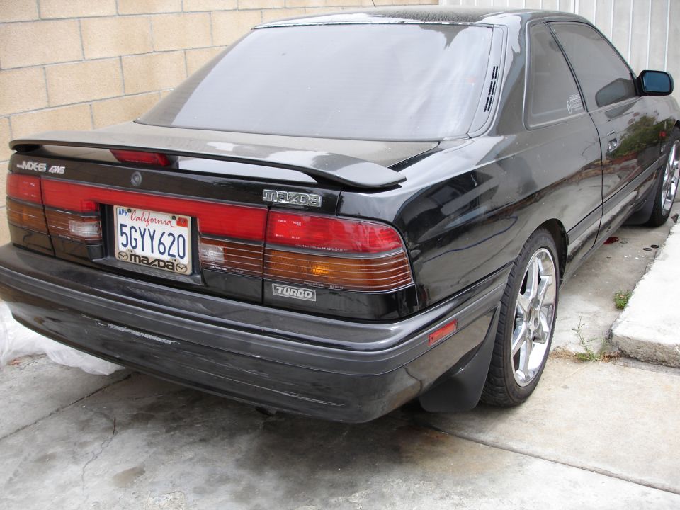Black Mazda MX-6 4WS Turbo coupe rear three-quarter with lip spoiler and alloy wheels