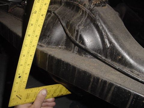 1971 Ford Bronco - A yellow speed square is used to measure a dark, dusty vehicle suspension component.