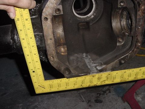 1971 Ford Bronco - A differential housing is measured with a yellow tape measure, showing its internal components and external rust.