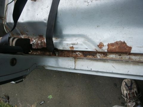 1982 Ford Bronco - The lower door frame of a vehicle shows significant rust damage and corrosion.