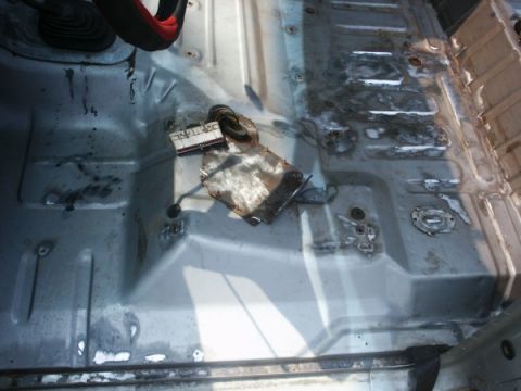 1982 Ford Bronco - The interior floor pan of a 1982 Ford Bronco shows exposed metal and wiring, suggesting preparation for a spray-in liner.