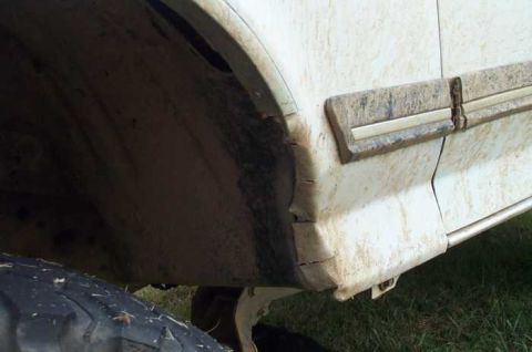 1988 Ford Bronco - Close-up of the side of a 1988 Ford Bronco, showing the rear wheel well and lower body trim.