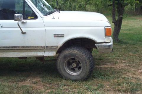 1988 Ford Bronco - This white Ford truck has a "Bronco" badge on the fender, but the body style indicates it's an F-Series model from the early 90s.