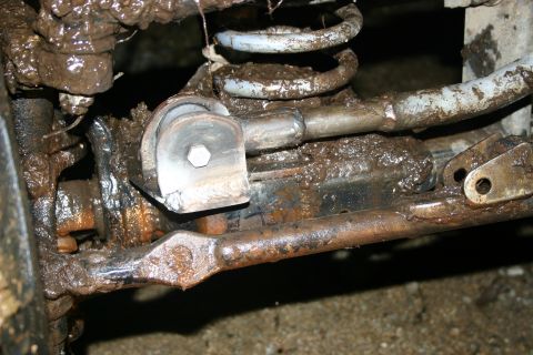 2003 Jeep TJ - This image shows the heavily soiled suspension system of a vehicle, with mud obscuring many details.