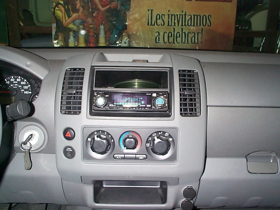 Dashboard of a 2005 Nissan Frontier with radio, climate controls, and keys in ignition