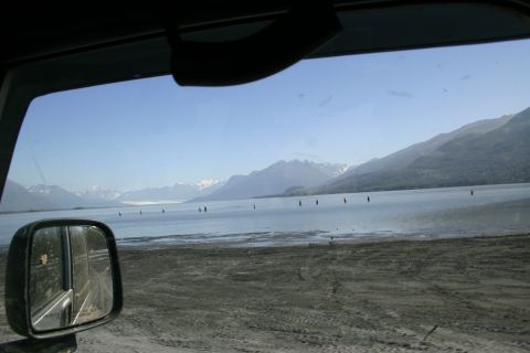 2003 Jeep TJ - View from a vehicle's side mirror shows a landscape with a lake, distant mountains, and a clear sky.