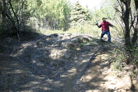 2003 Jeep TJ - Man on a rocky, wooded trail, possibly in a mountainous area.