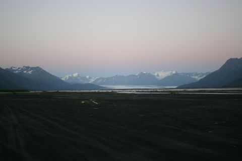 2003 Jeep TJ - A wide, dark, flat plain stretches towards a distant glacial valley and towering, snow-covered mountains at twilight.