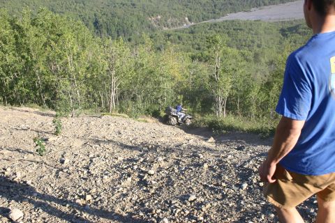 2003 Jeep TJ - ATV rider navigates a steep, rocky trail through a wooded area.