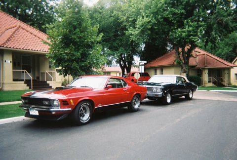 1972 Ford Ranchero - A red 1970 Ford Mustang Mach 1 is parked in front of a black 1969 Chevrolet Impala on a residential street.