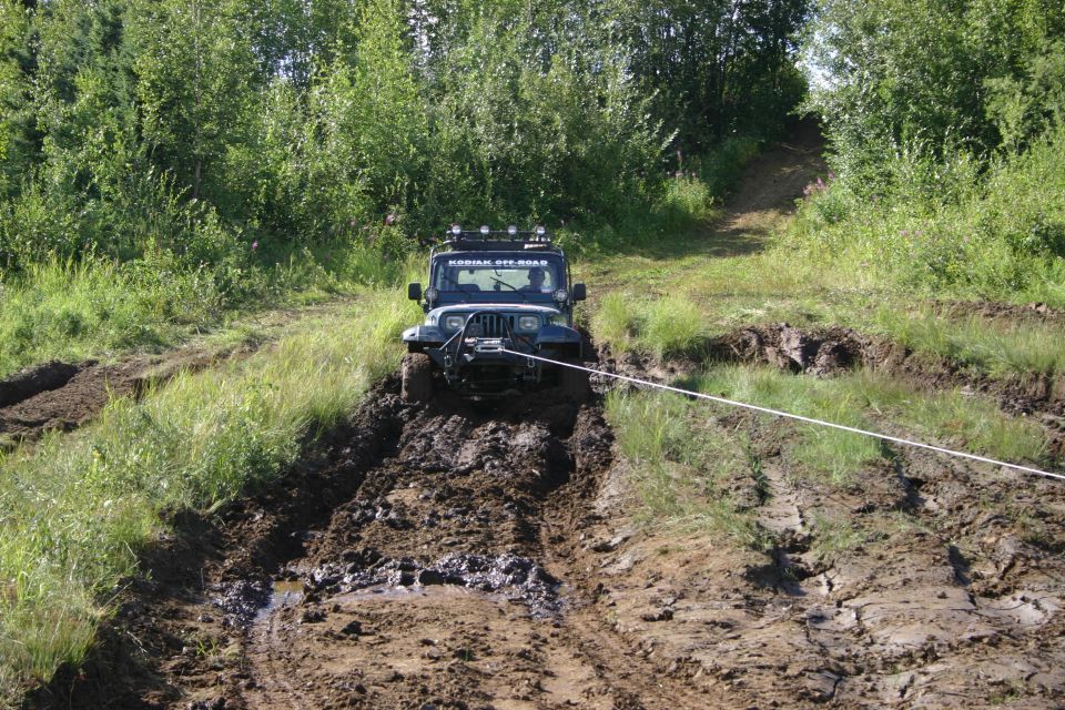 Jeep TJ winching itself out of a mud pit on an off-road trail