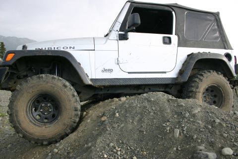 2003 Jeep TJ - White 2003 Jeep TJ Rubicon with soft top, side view, on a dirt pile.