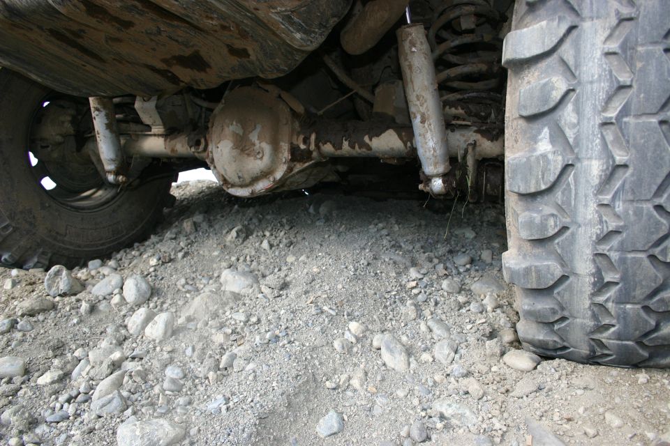 Rear axle and suspension of a vehicle on rocky terrain