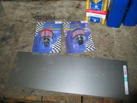 1995 Ford Bronco - Engine breather filters and sheet metal are laid out on a workbench.