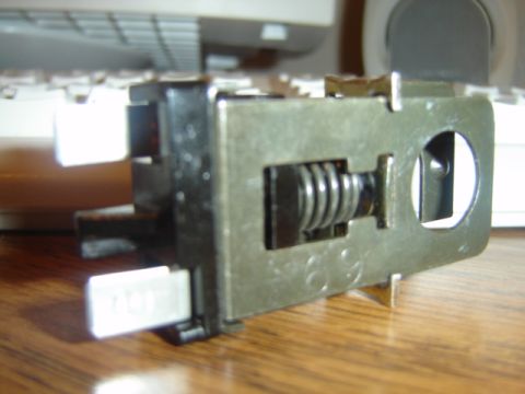 1988 Ford LTD Crown Victoria - A close-up view of a metal switch component with a coiled spring mechanism.