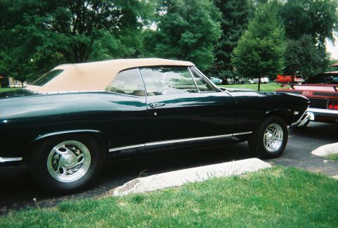 1972 Ford Ranchero - A dark green convertible with a tan top is parked next to another vehicle. The car's body style suggests it is a 1968 Chevrolet Chevelle Ma…