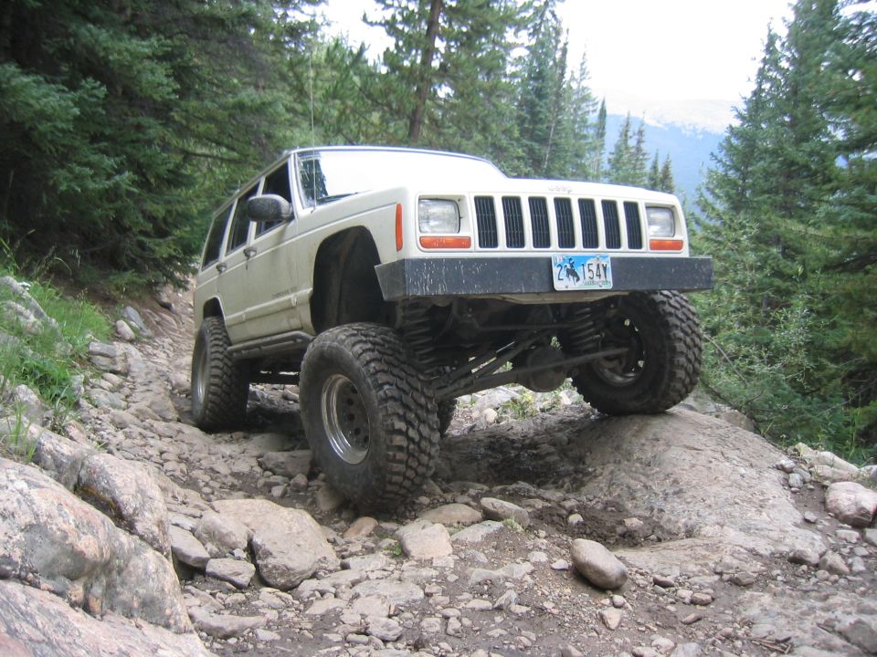 White 1997 Jeep Cherokee navigating a rocky mountain trail