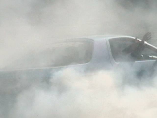 Car doing a burnout obscured by thick tire smoke
