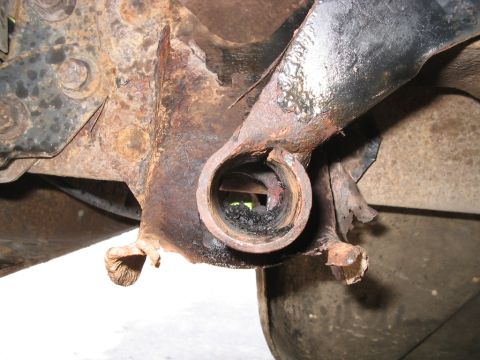 1992 Ford Bronco - Close-up of a severely corroded vehicle suspension component, showing significant wear and damage.