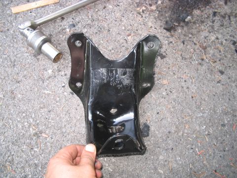 1992 Ford Bronco - Leaf spring shackle bracket, likely for a truck or SUV, with a socket wrench nearby.