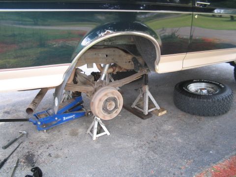 1992 Ford Bronco - The rear axle and suspension of a 1992 Ford Bronco are visible while being serviced.