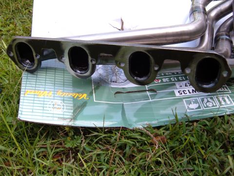 1978 Ford Bronco - Close-up of exhaust headers resting on a box, with visible part numbers and text.