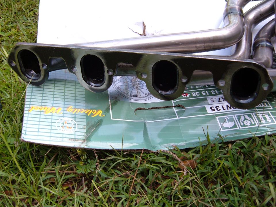 Exhaust headers on a green box with text 'Velocity Wheel' and part numbers