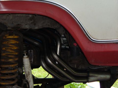 1978 Ford Bronco - Close-up view of exhaust headers and suspension components on a vehicle.