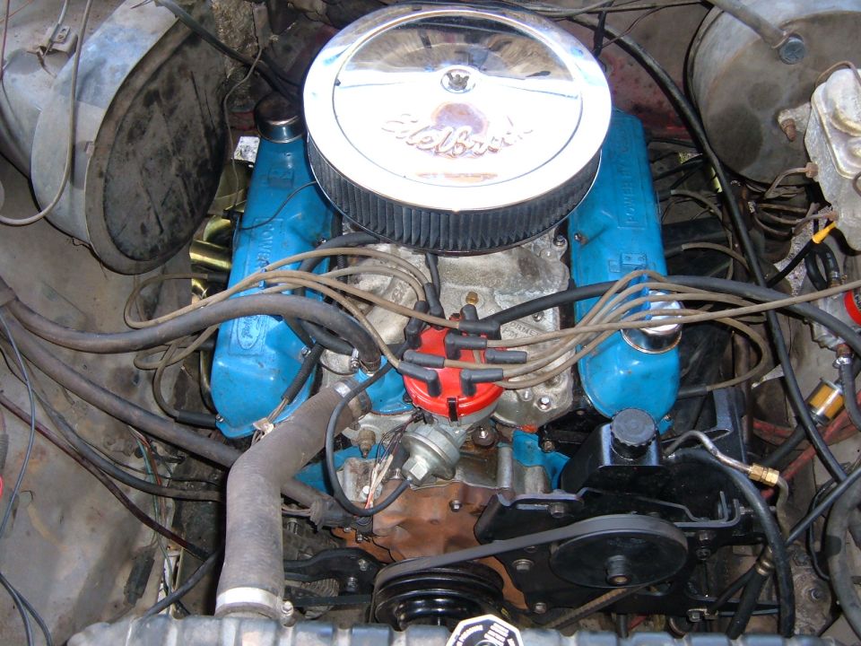 Close-up of a blue Ford V8 engine with a chrome air cleaner and red distributor cap