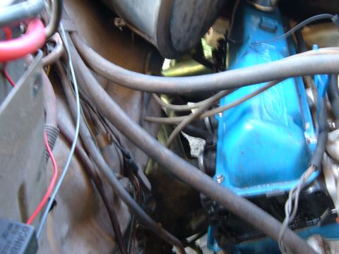 1978 Ford Bronco - Close-up view of an engine bay, showing blue valve covers and a complex network of hoses and wiring.