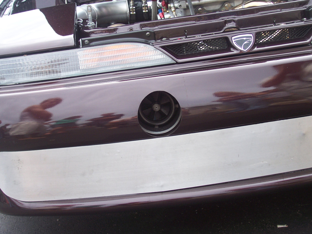 Front bumper with circular vent and badge