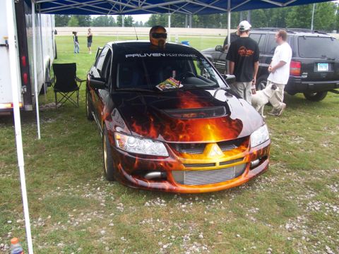 1990 Ford Probe - Customized Mitsubishi Lancer Evolution with flame graphics and a performance banner is parked outdoors.