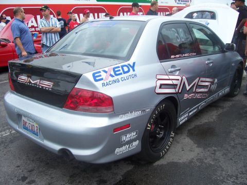 1990 Ford Probe - Silver sedan with racing decals, including BMS and EXEDY, seen from the rear.
