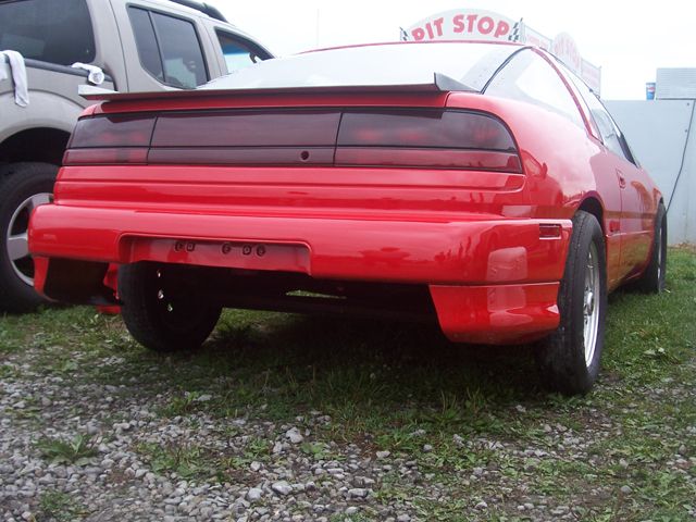 Red 1990 Ford Probe rear view with spoiler and aftermarket bumper