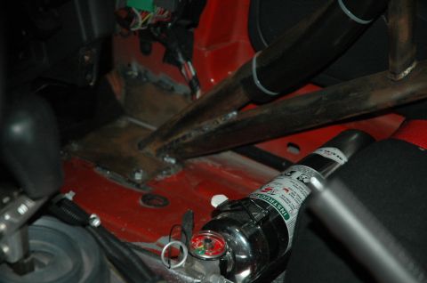 2000 Ford Mustang - Interior view of a car's cabin, a roll cage and a fire extinguisher mounted near the floor.