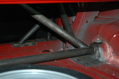 2000 Ford Mustang - Close-up view of a custom roll cage installed in the interior of a red vehicle.