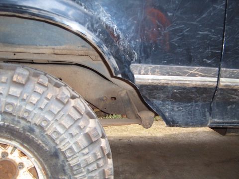 1988 Ford Bronco - Close-up view of the rear wheel well and fender trim on a black 1988 Ford Bronco.