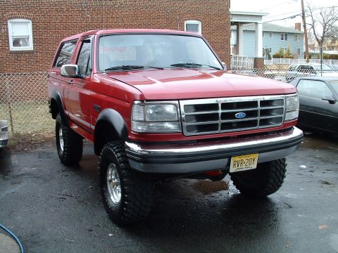 1994 Ford Bronco - This red Ford Bronco features a lifted suspension and aggressive off-road tires.