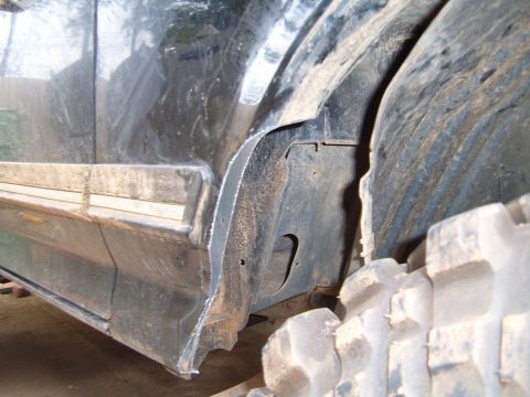 1988 Ford Bronco - Detail of the fender and tire well on a vehicle, with evidence of modification.