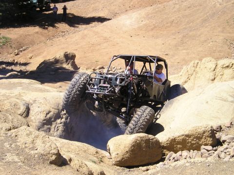 1989 Ford Bronco - Custom buggy tackles a challenging rock crawl course during an off-road event.
