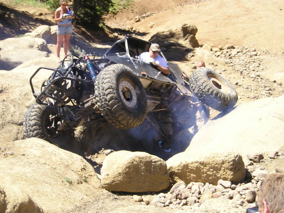 Off-road buggy climbing rocks, driver visible