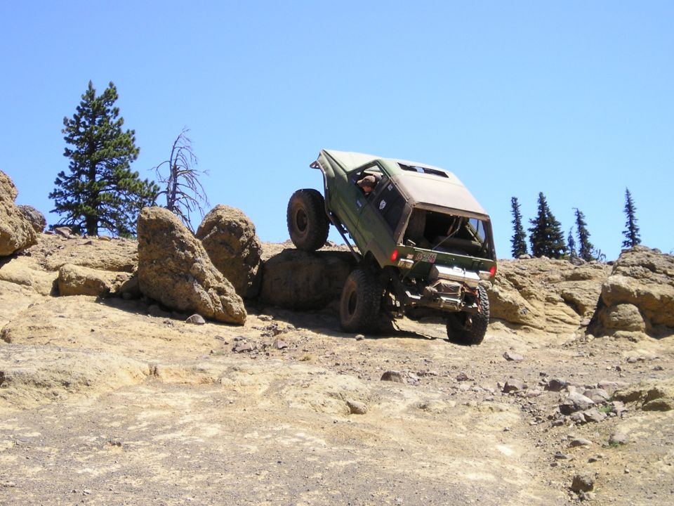 1989 Ford Bronco climbing over large rocks on an off-road trail