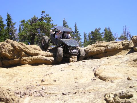 1989 Ford Bronco - This custom buggy navigates a rocky trail under a clear blue sky.